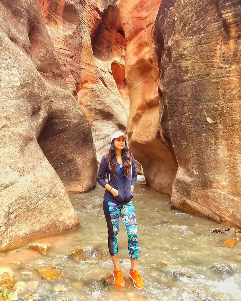 Woman wearing a green sweater, jeans, and ankle boots at a snowy mountain destination