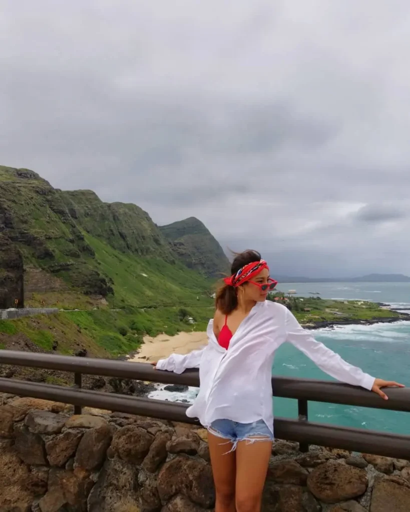 Woman wearing a white button-down shirt and denim shorts on a coastal trip