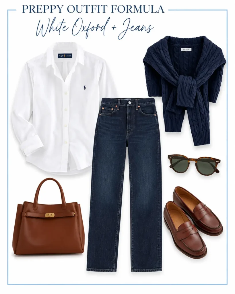 Preppy outfit featuring a white Oxford shirt, dark straight-leg jeans, navy cable-knit sweater, brown penny loafers, and leather handbag.